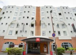 l'hôtel ibis a un auvent rouge au-dessus de l'entrée