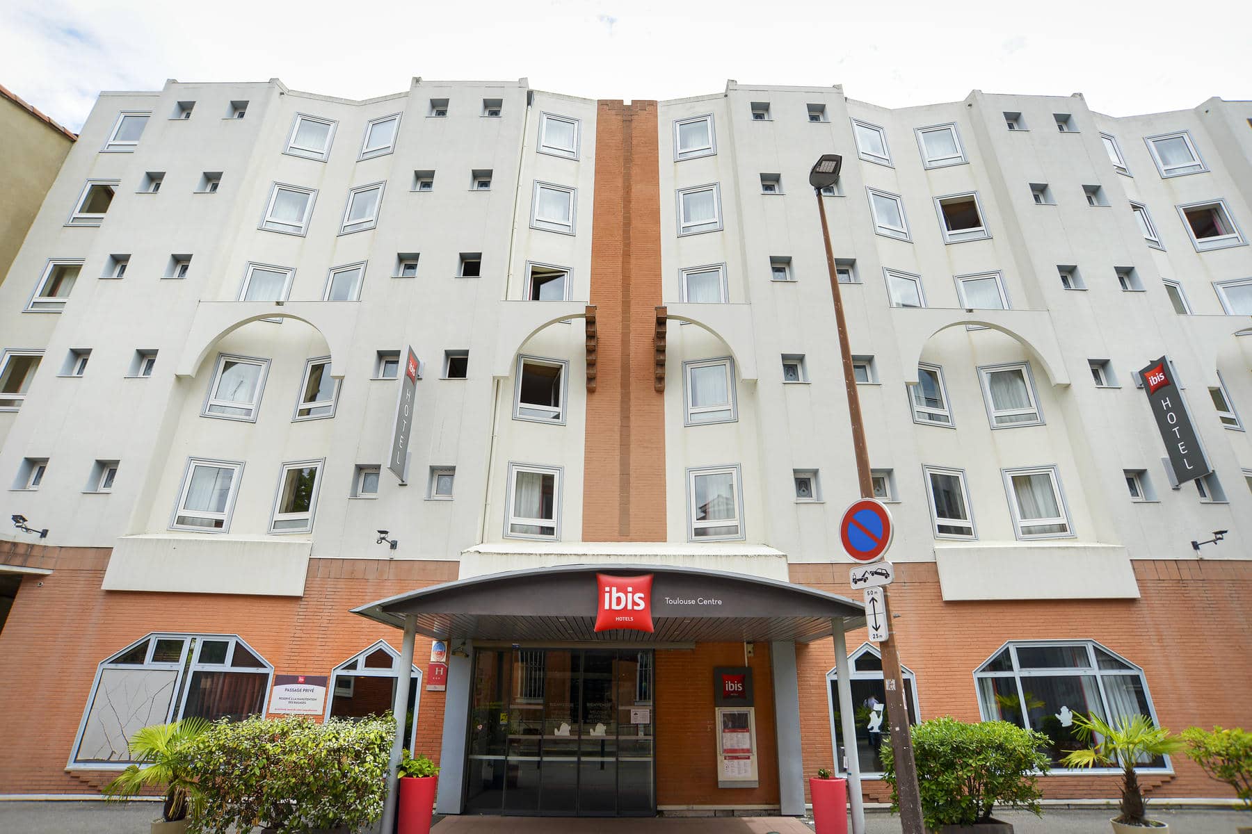 l'hôtel ibis a un auvent rouge au-dessus de l'entrée