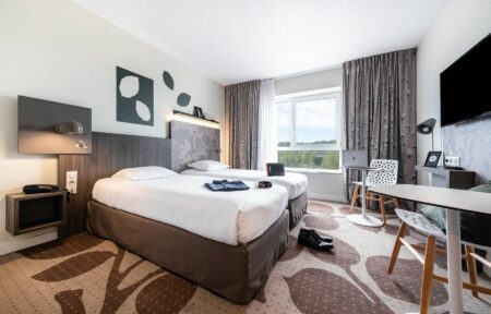 une chambre d'hôtel avec deux lits et un bureau