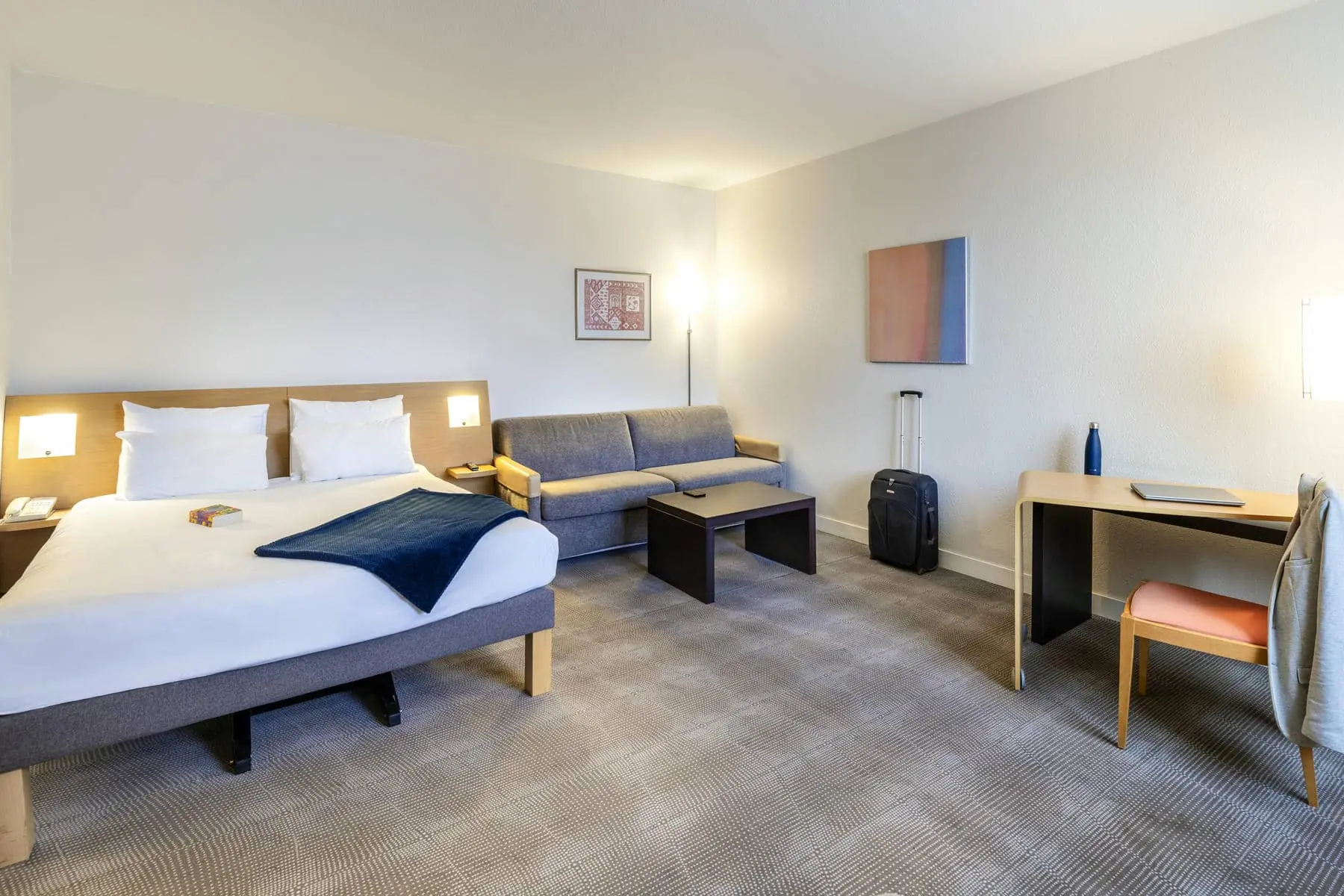 une chambre d'hôtel avec un lit, un canapé et un bureau