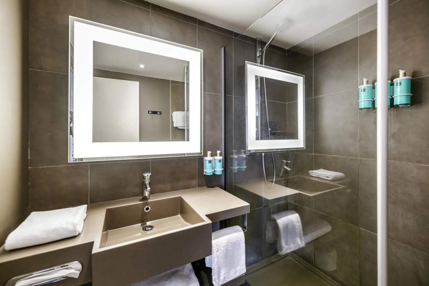 une salle de bain avec un lavabo, un miroir et une douche