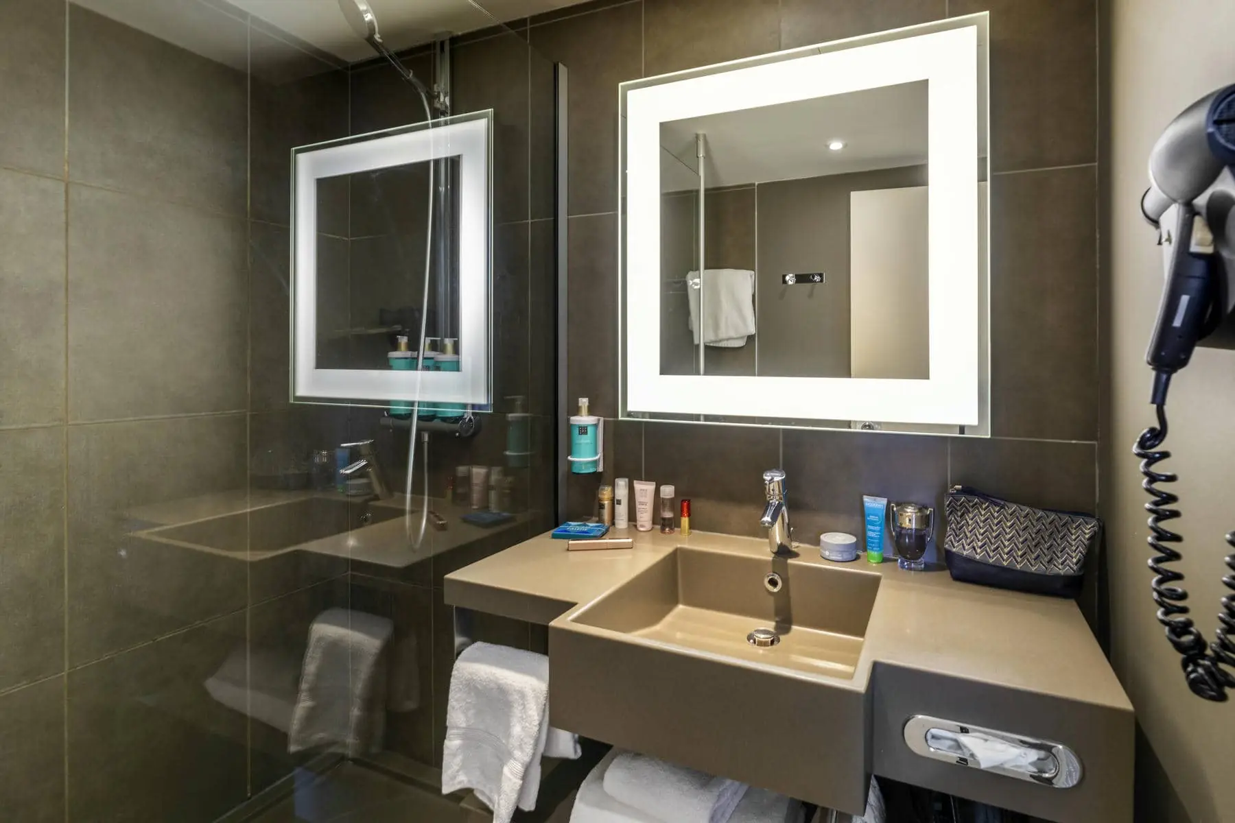 une salle de bain avec un lavabo, un miroir et un sèche-cheveux