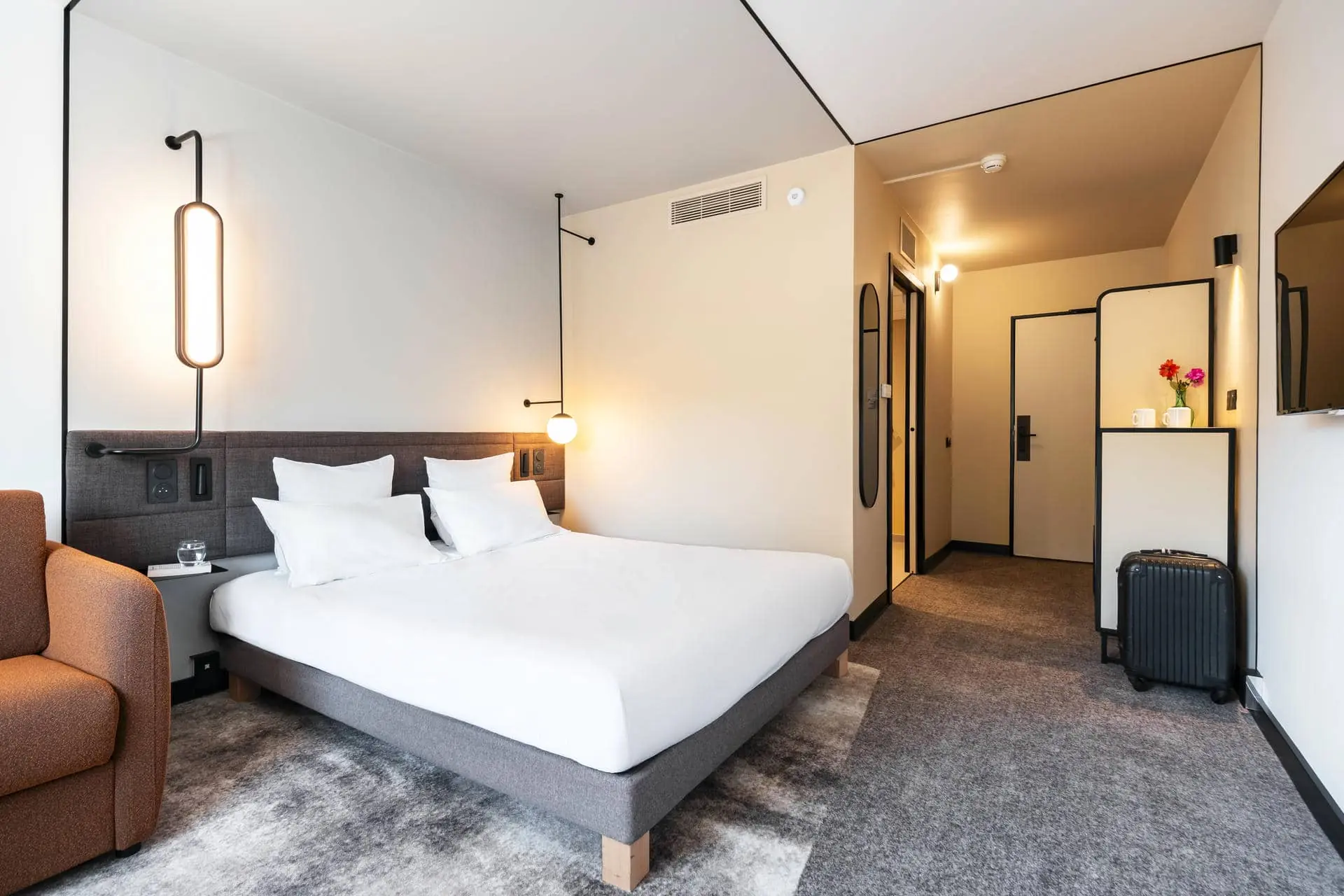 une chambre d'hôtel avec un lit et une valise