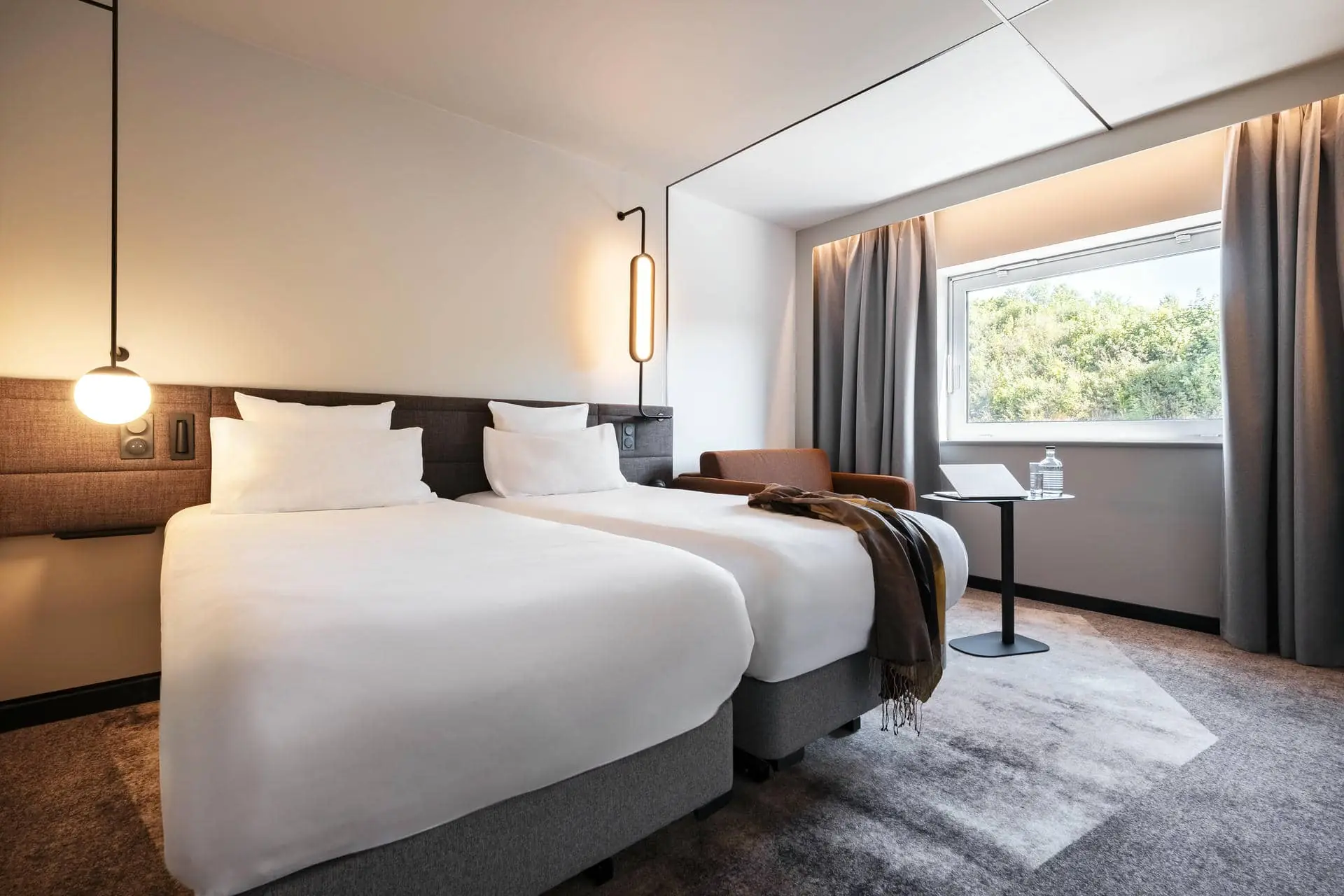 une chambre d'hôtel avec deux lits et une chaise