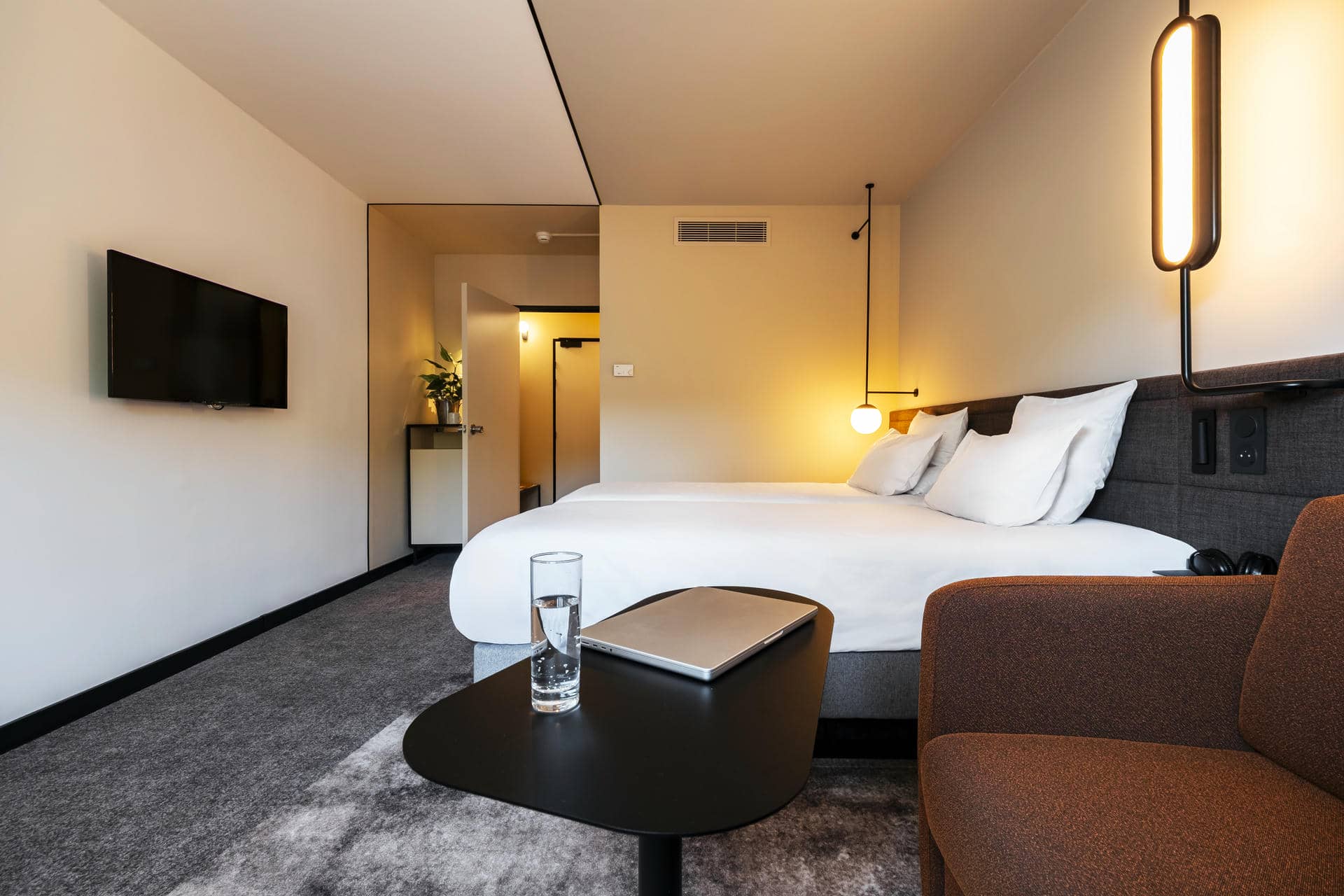 une chambre d'hôtel avec deux lits et une table sur laquelle est posé un ordinateur portable