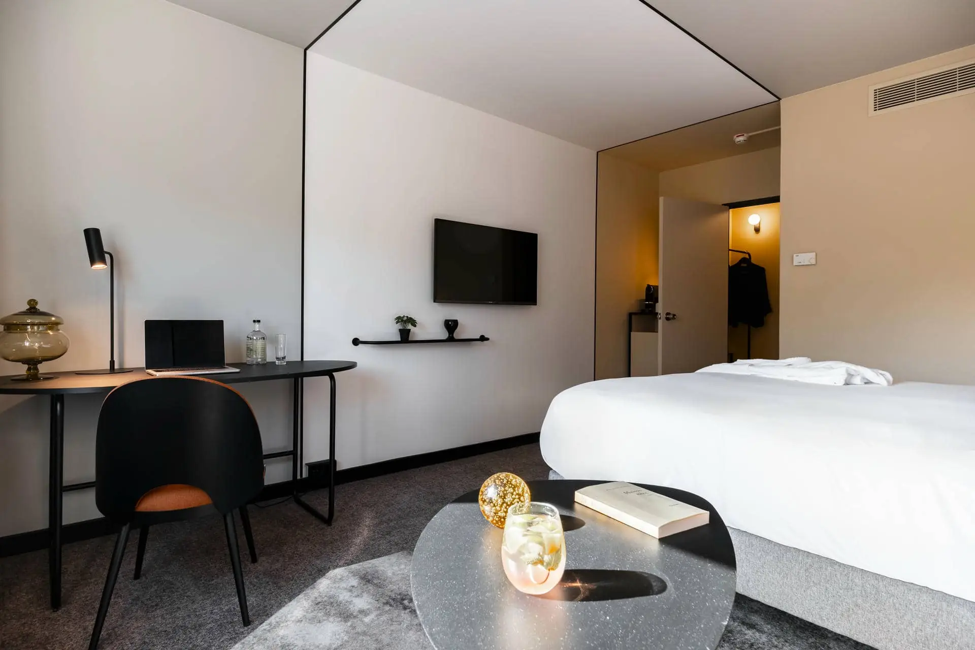une chambre d'hôtel avec un lit, un bureau et une télévision à écran plat