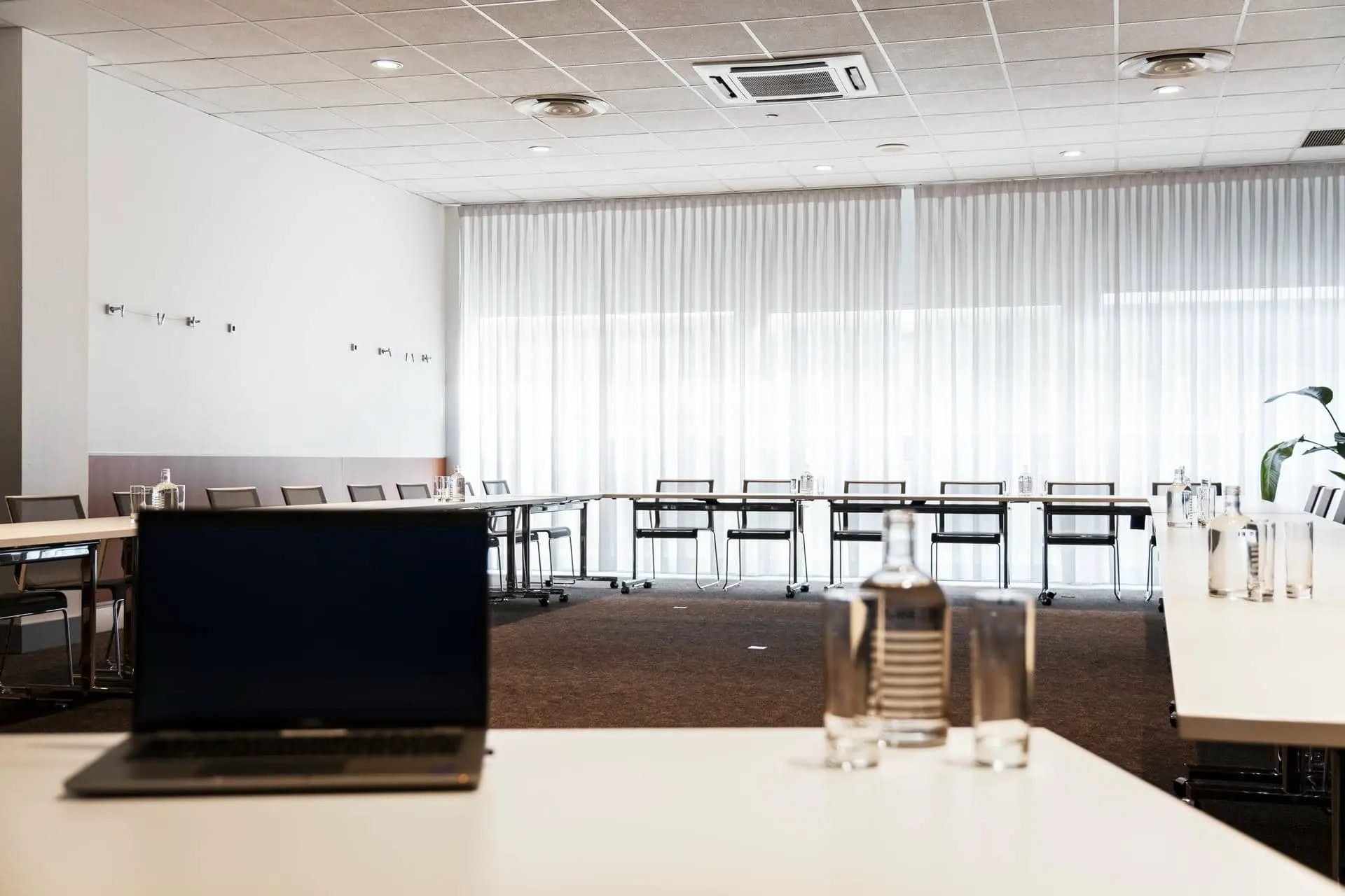 a dell laptop sits on a table in a conference room