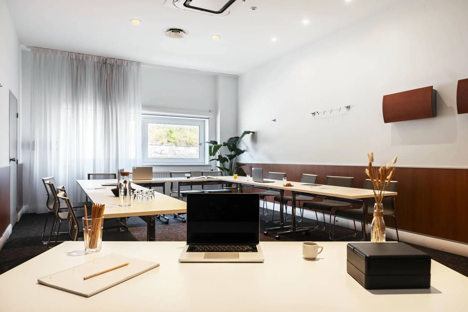 a conference room with tables and chairs and a laptop on the desk