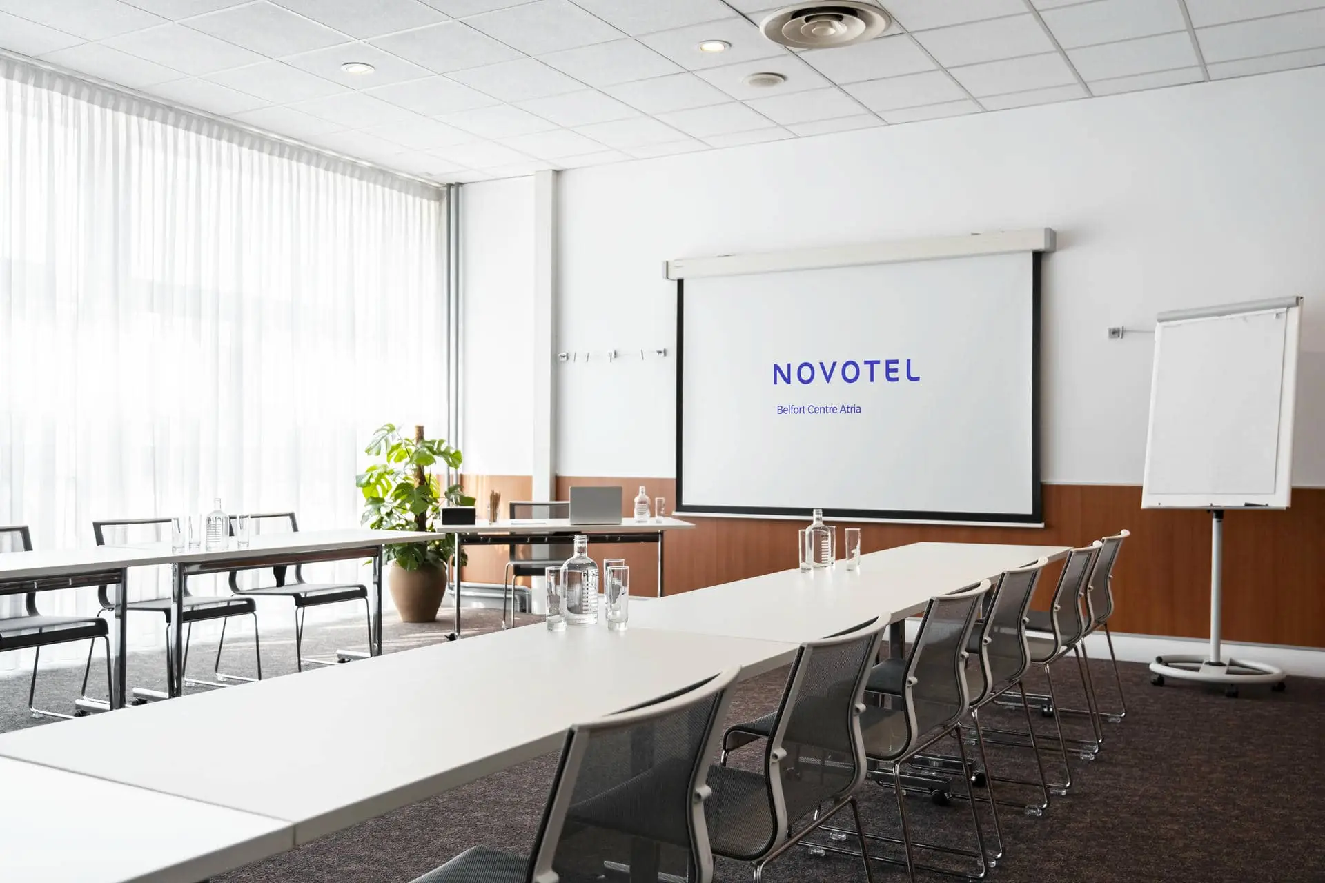 a conference room with a projector screen that says novotel
