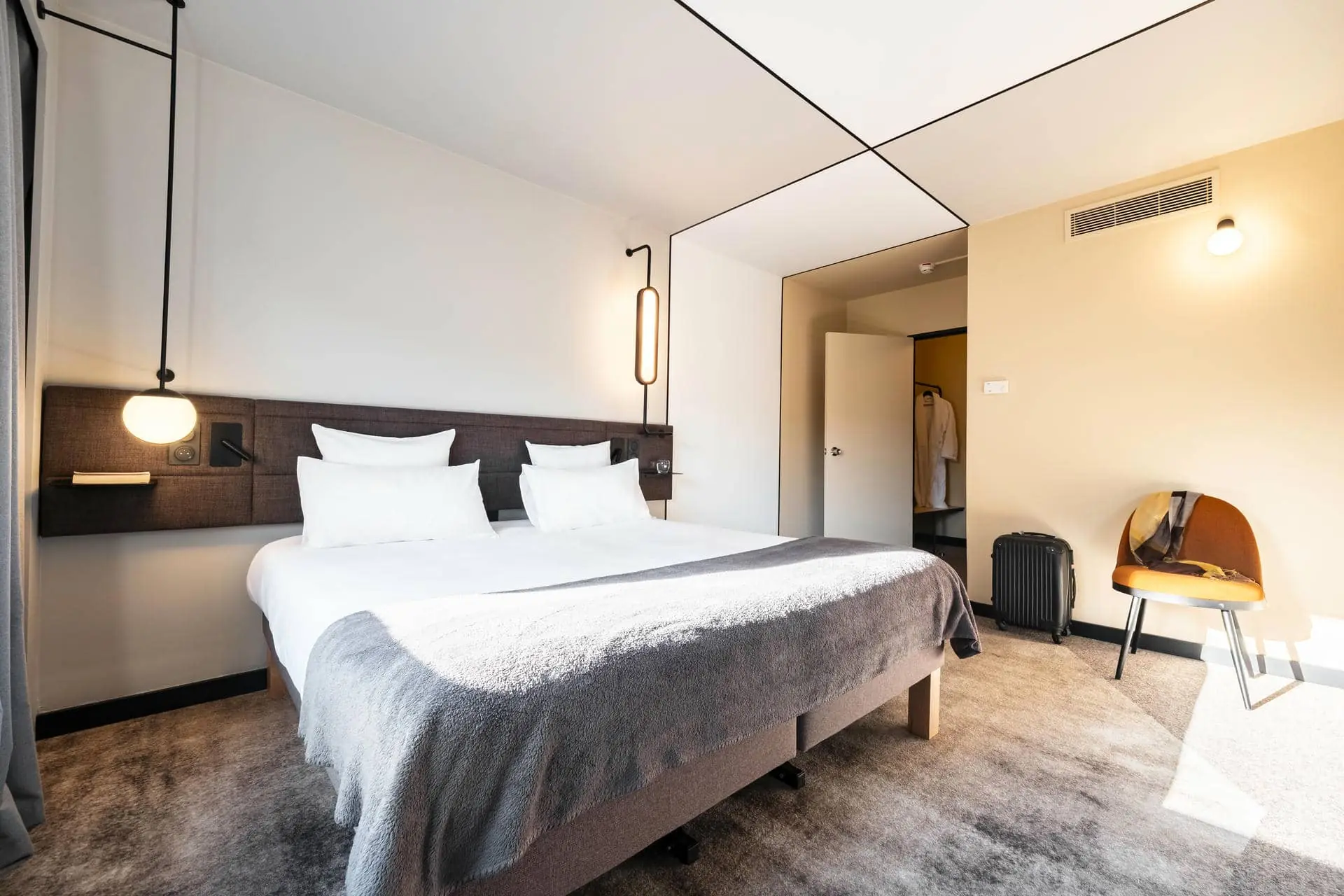 une chambre d'hôtel avec un grand lit et une chaise