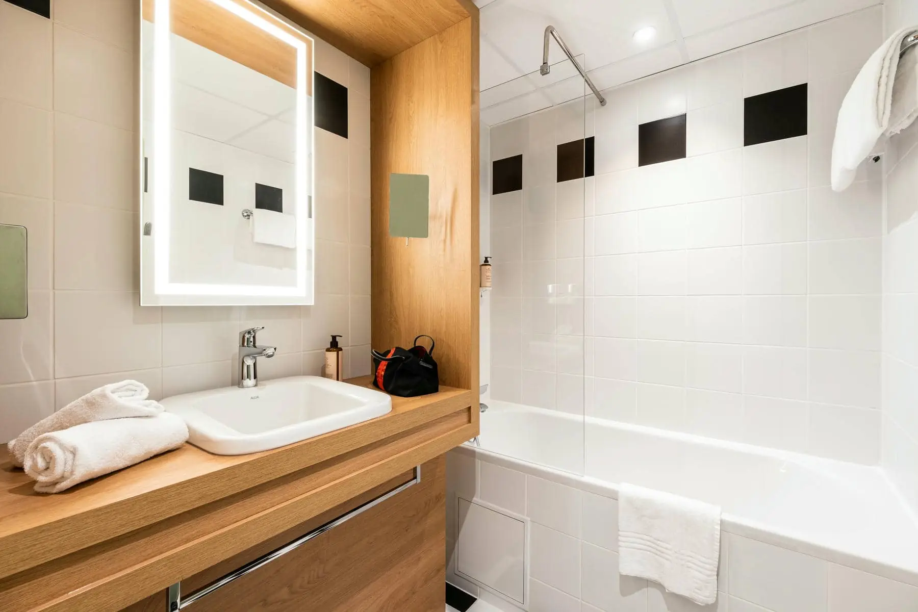 une salle de bain avec un lavabo, un miroir et une baignoire