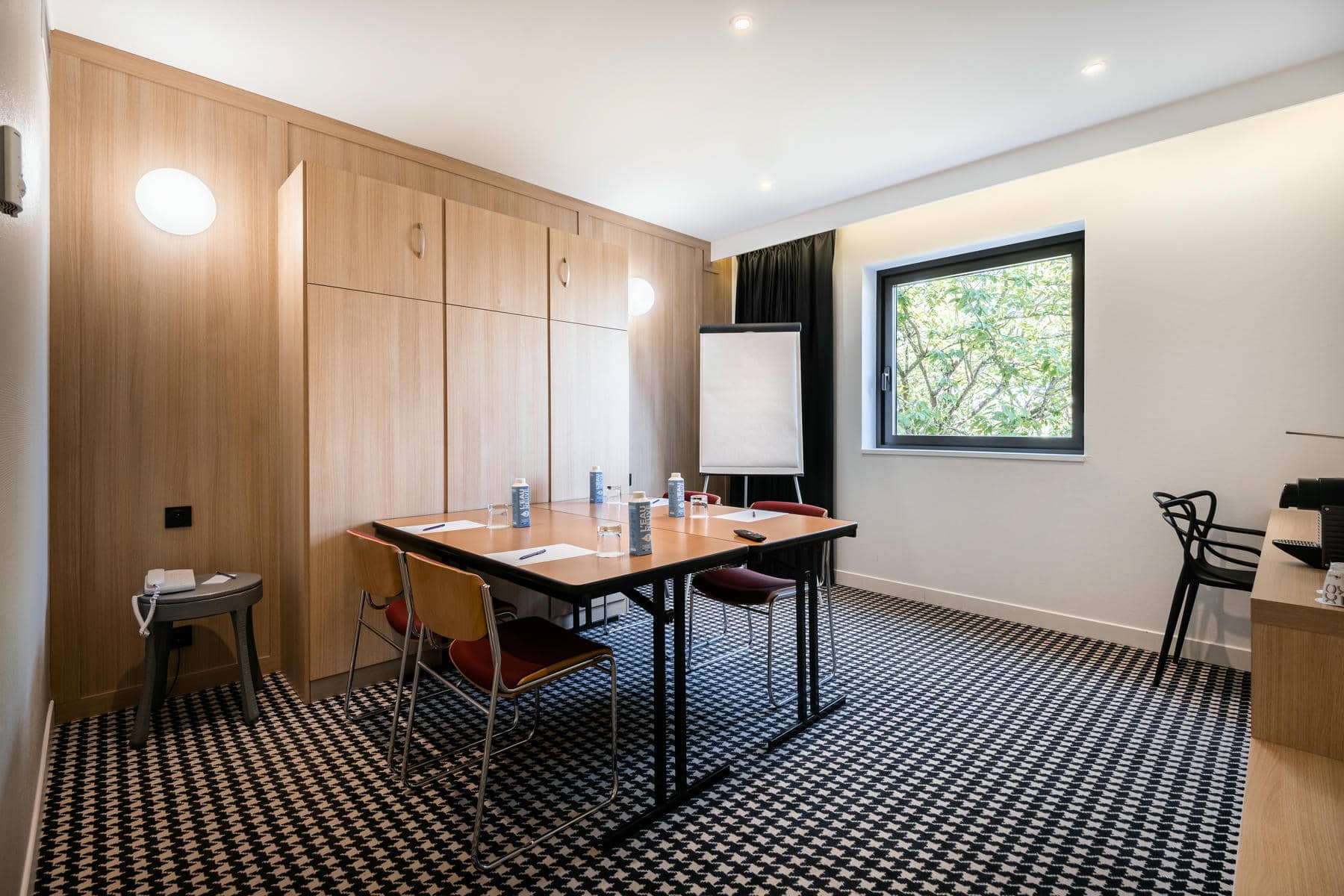 une salle de conférence avec une table et des chaises et un tableau blanc sur lequel est écrit "eau