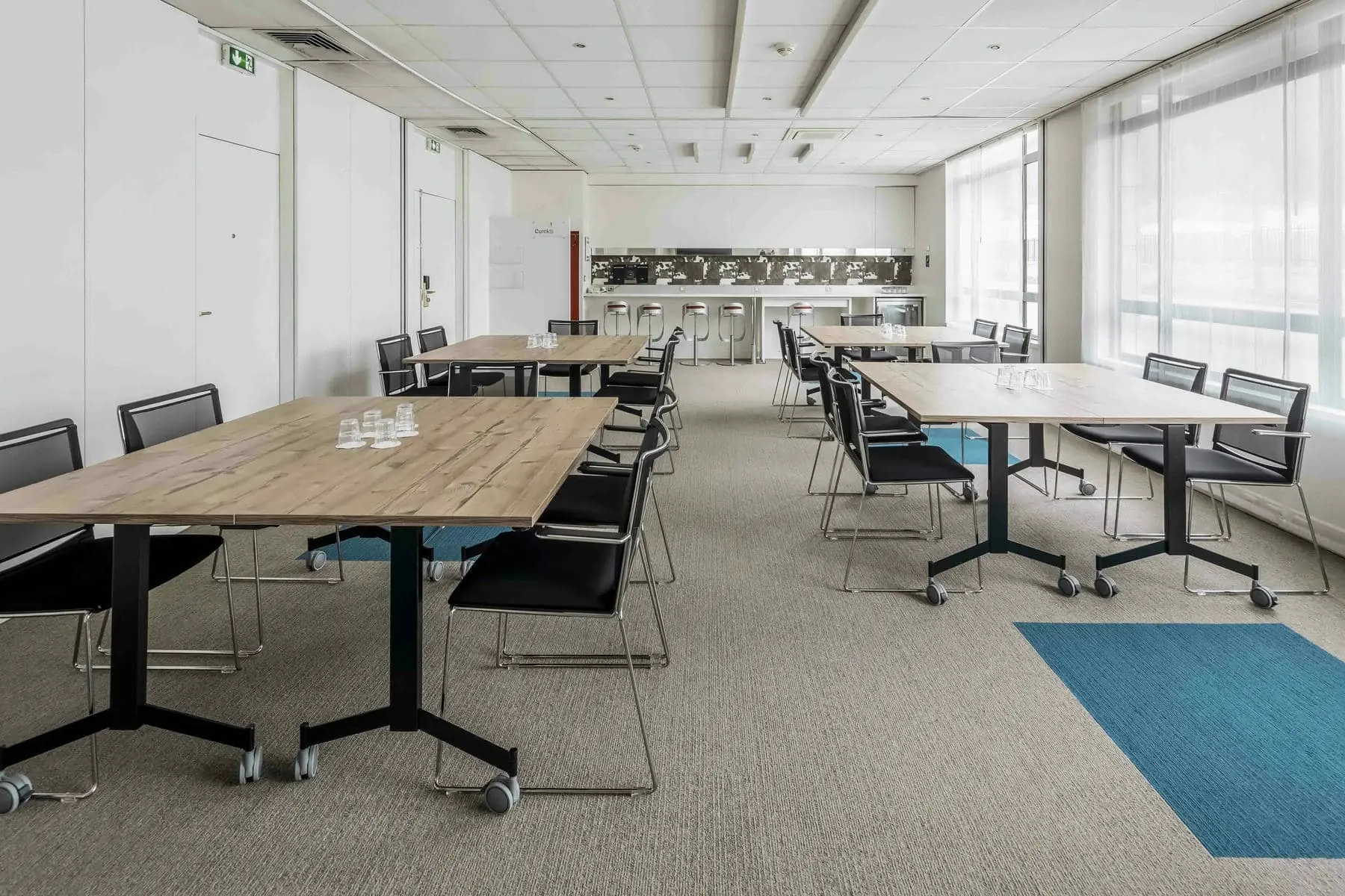 une pièce avec des tables et des chaises et un tapis bleu