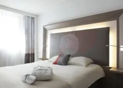 une chambre d'hôtel avec un grand lit et une grande tête de lit