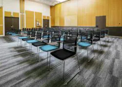 des rangées de chaises sont alignées dans une grande salle