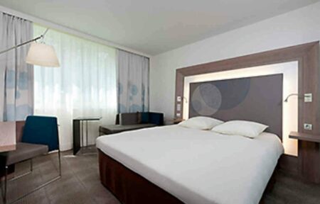 une chambre d'hôtel avec un grand lit et des chaises