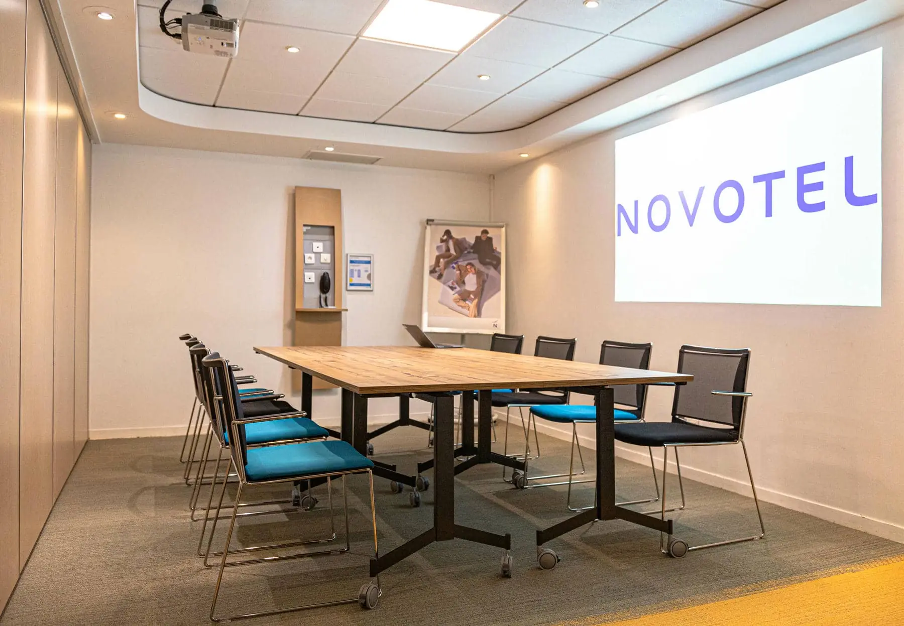 une salle de conférence avec un écran de projection sur lequel est inscrit novotel