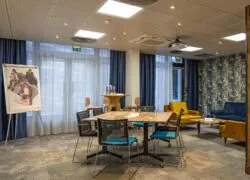 une salle avec des tables et des chaises et un projecteur au plafond