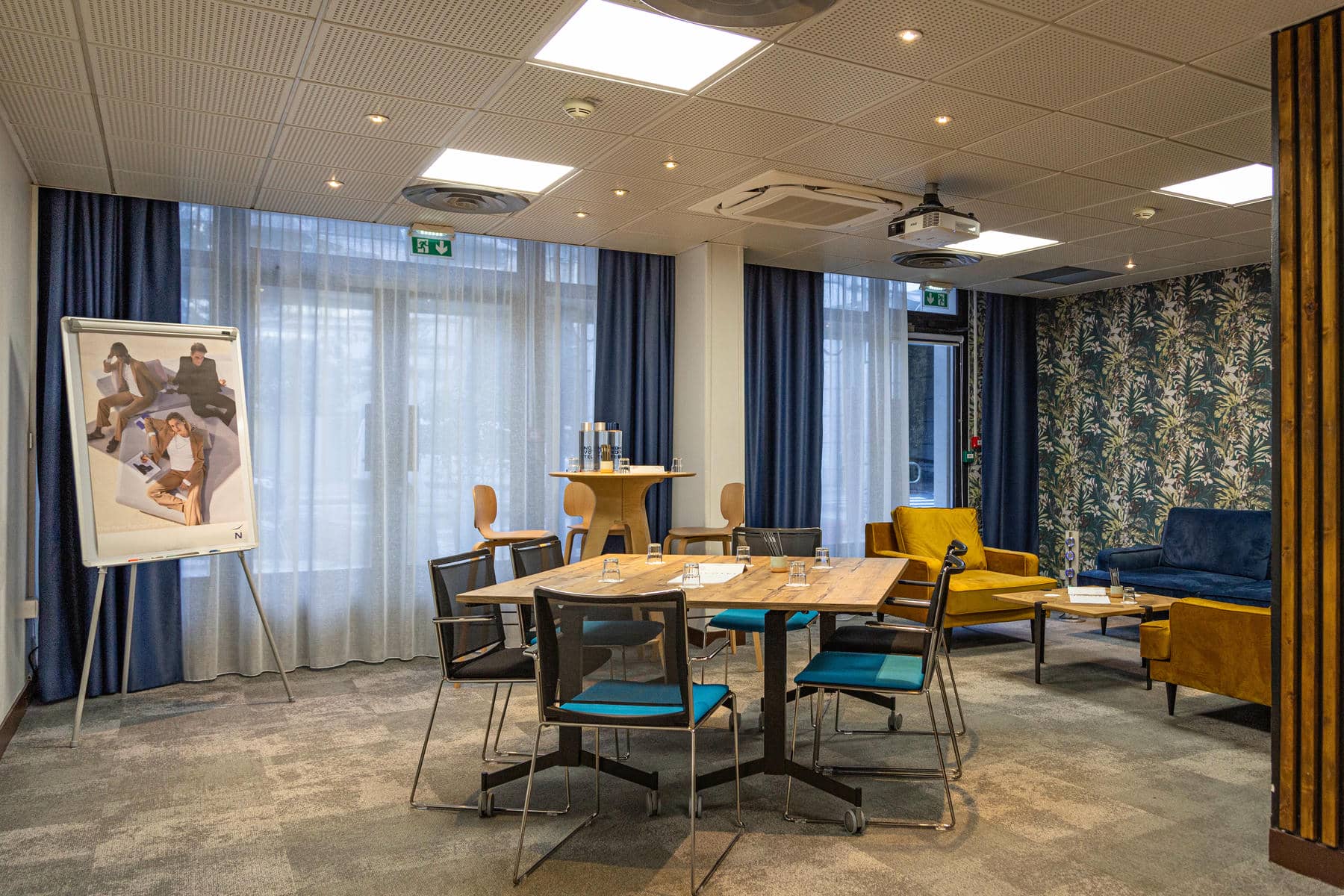 une salle avec des tables et des chaises et un projecteur au plafond