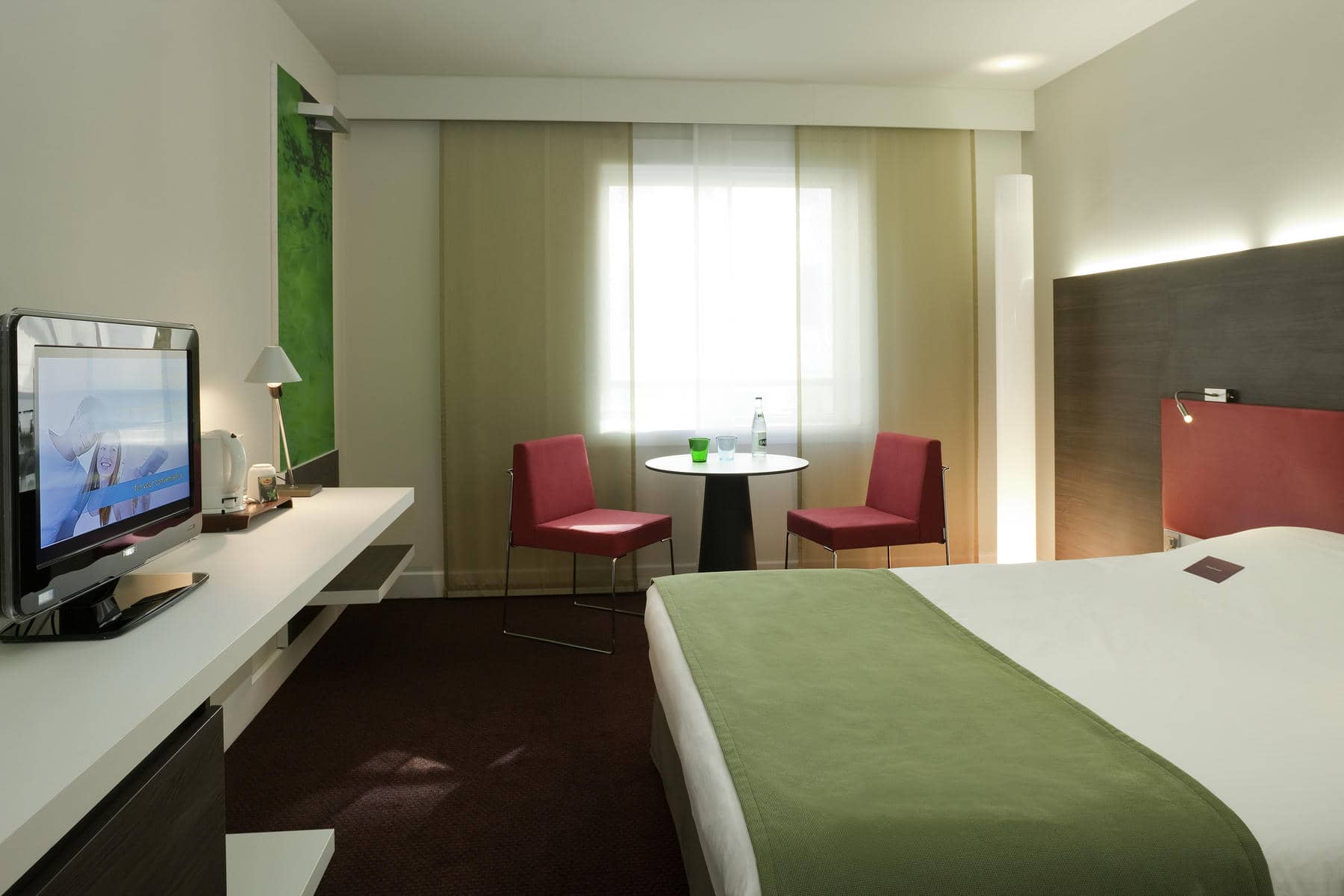 une chambre d'hôtel avec un lit king size et une télévision à écran plat