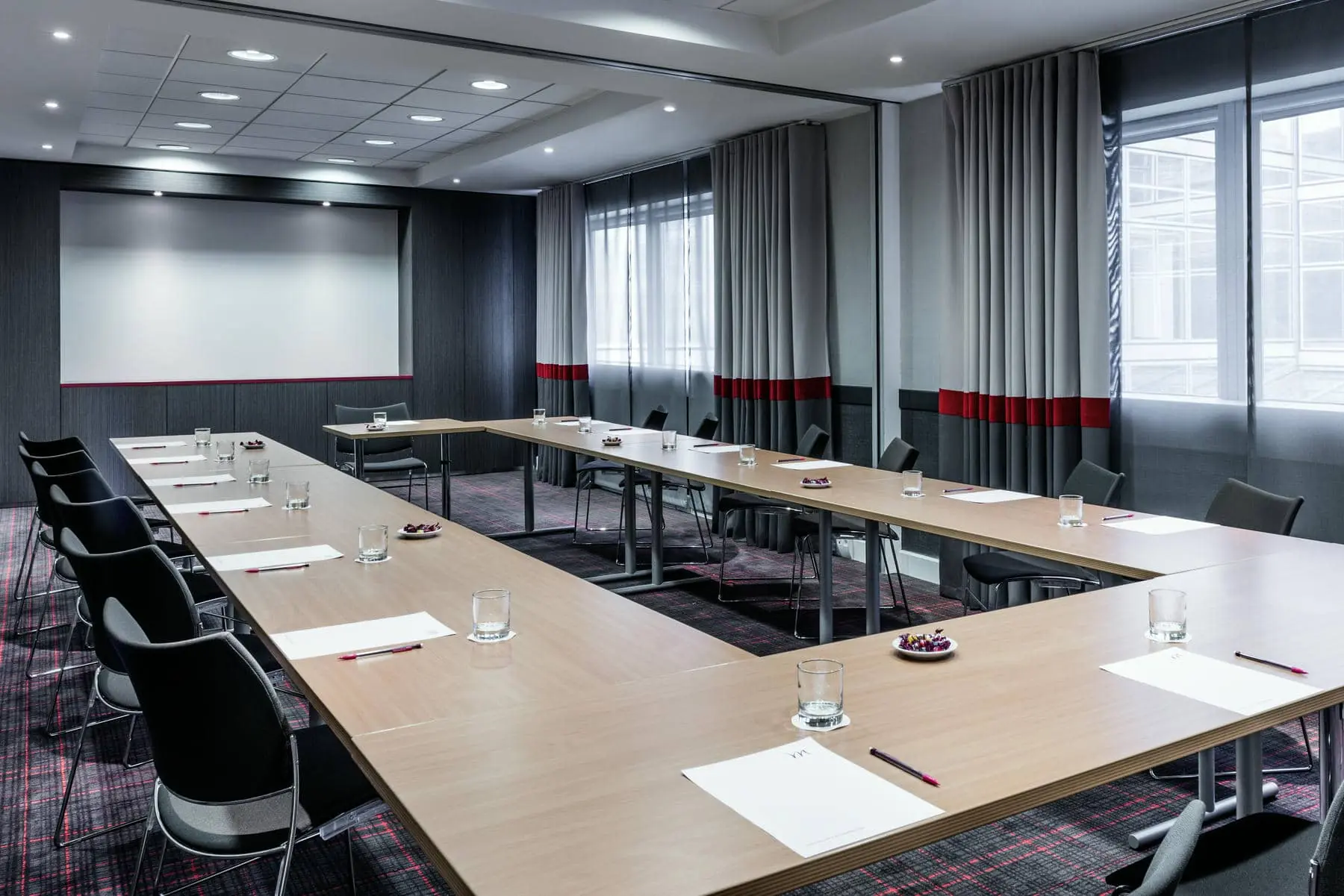 une salle de conférence avec des tables et des chaises pour une réunion