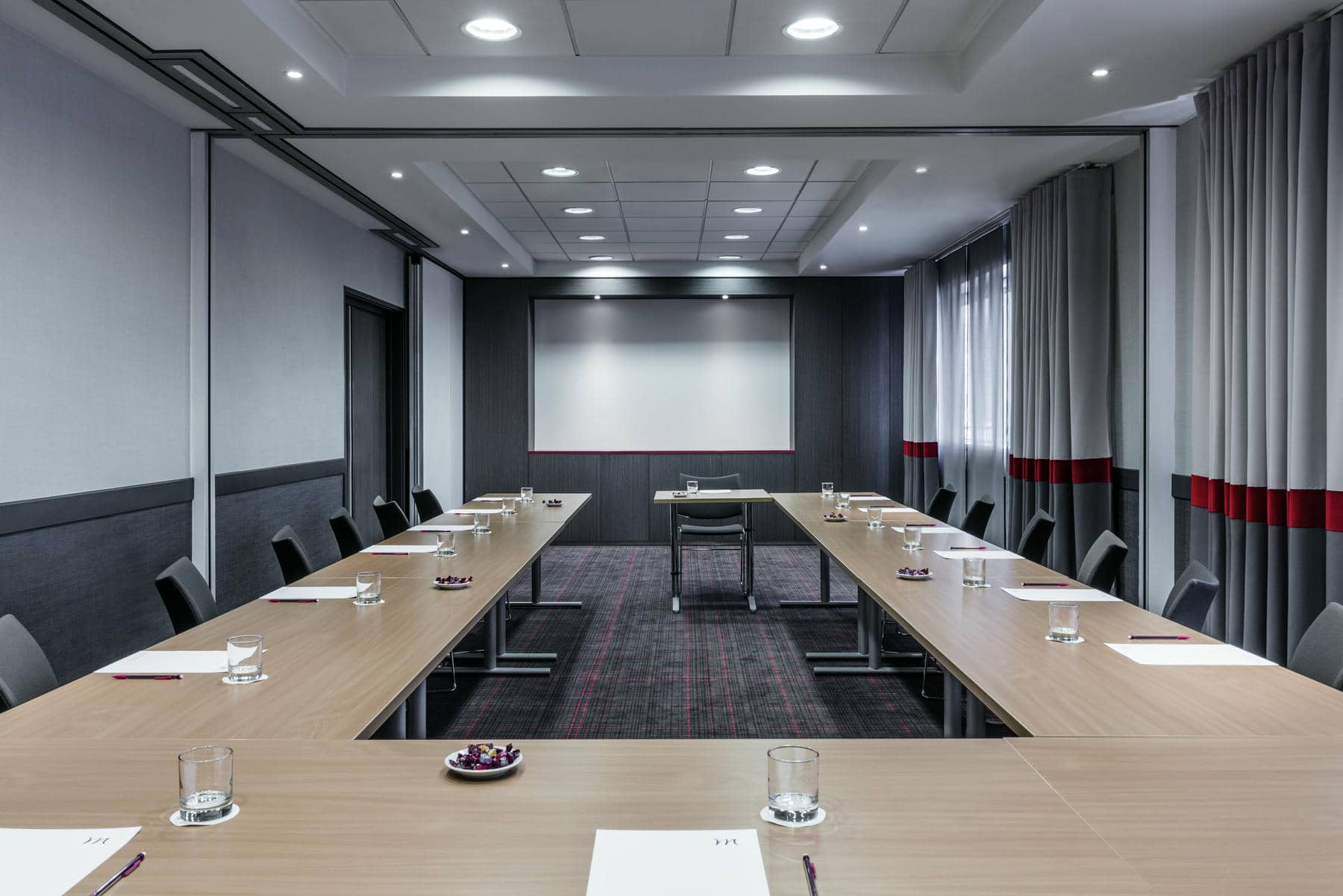 une salle de conférence avec des tables et des chaises pour une réunion