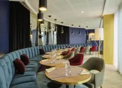 un restaurant avec des tables et des chaises et un mur bleu