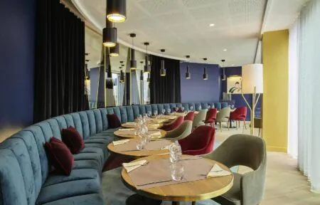 un restaurant avec des tables et des chaises et un mur bleu