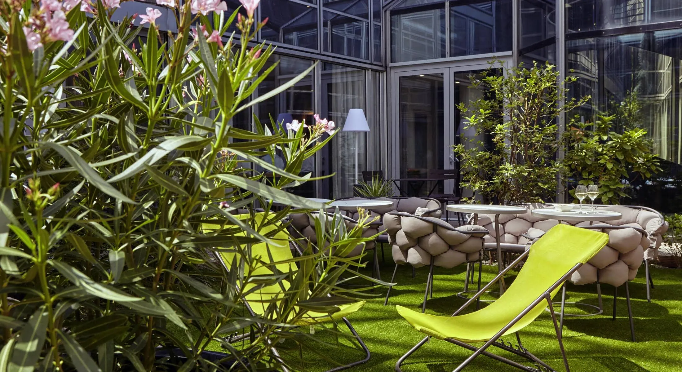un patio avec des chaises et des tables jaunes devant un bâtiment