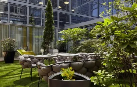 un jardin avec des tables et des chaises devant un bâtiment