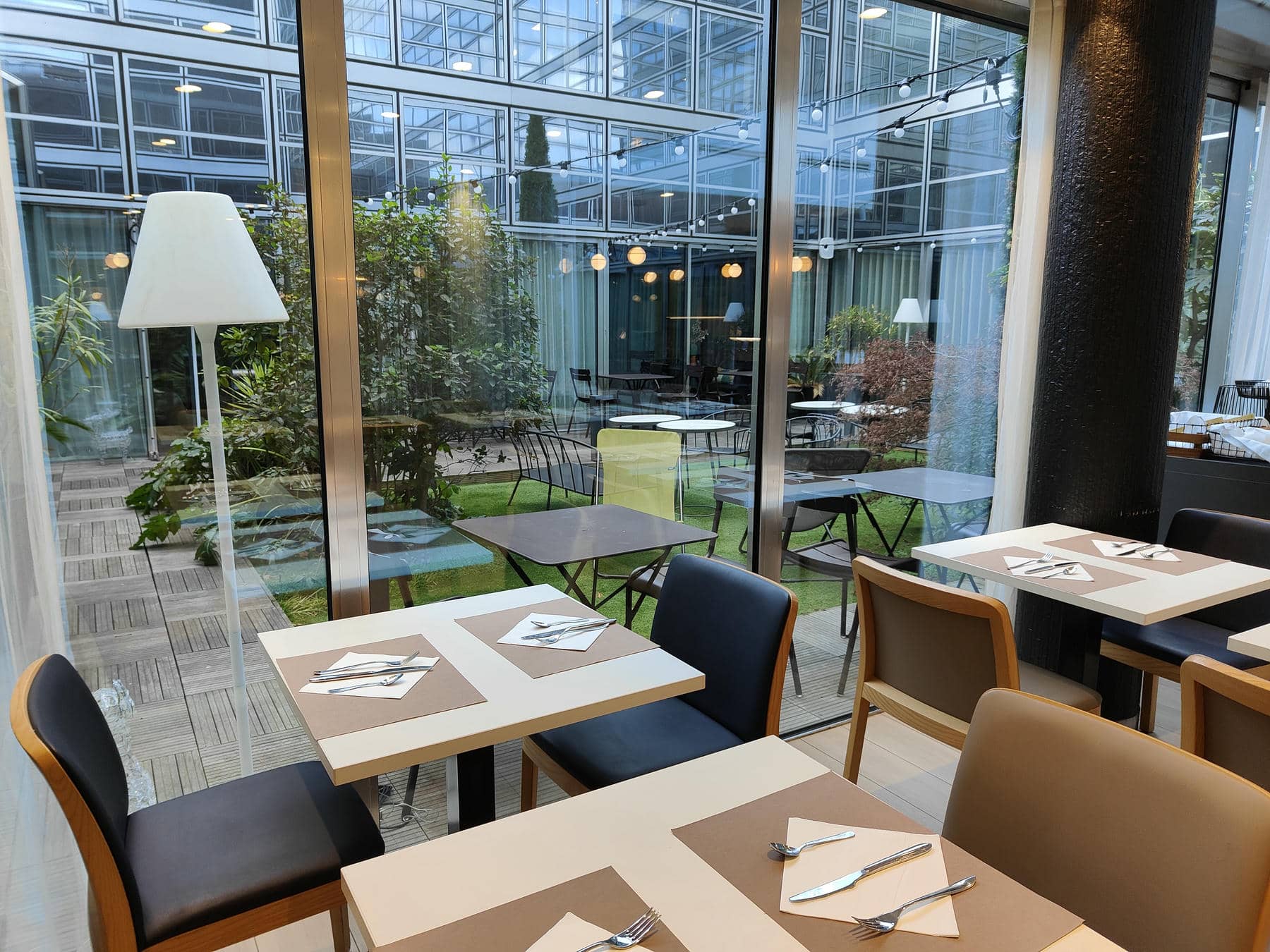 un restaurant avec des tables et des chaises et une grande fenêtre