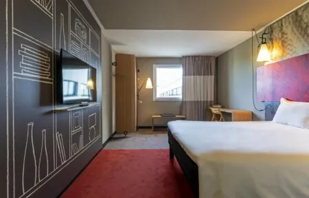 une chambre d'hôtel avec un lit et une télévision à écran plat