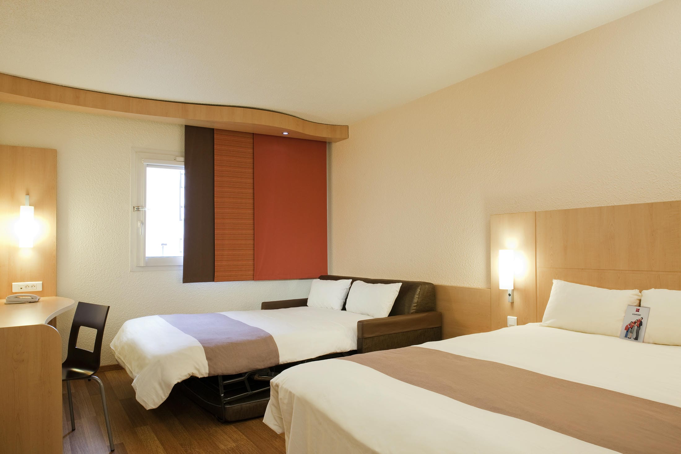 une chambre d'hôtel avec deux lits et un canapé