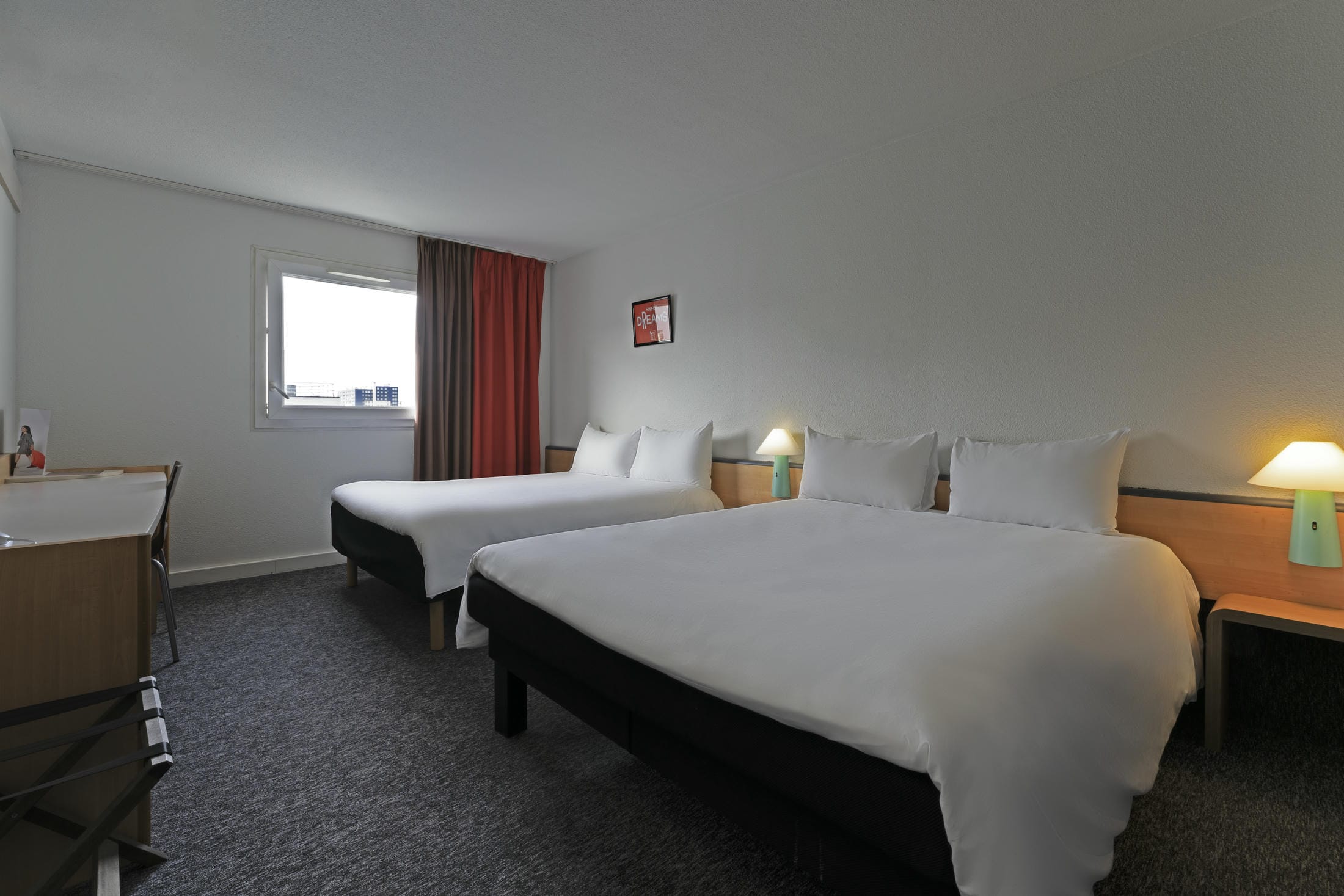 une chambre d'hôtel avec deux lits et un bureau