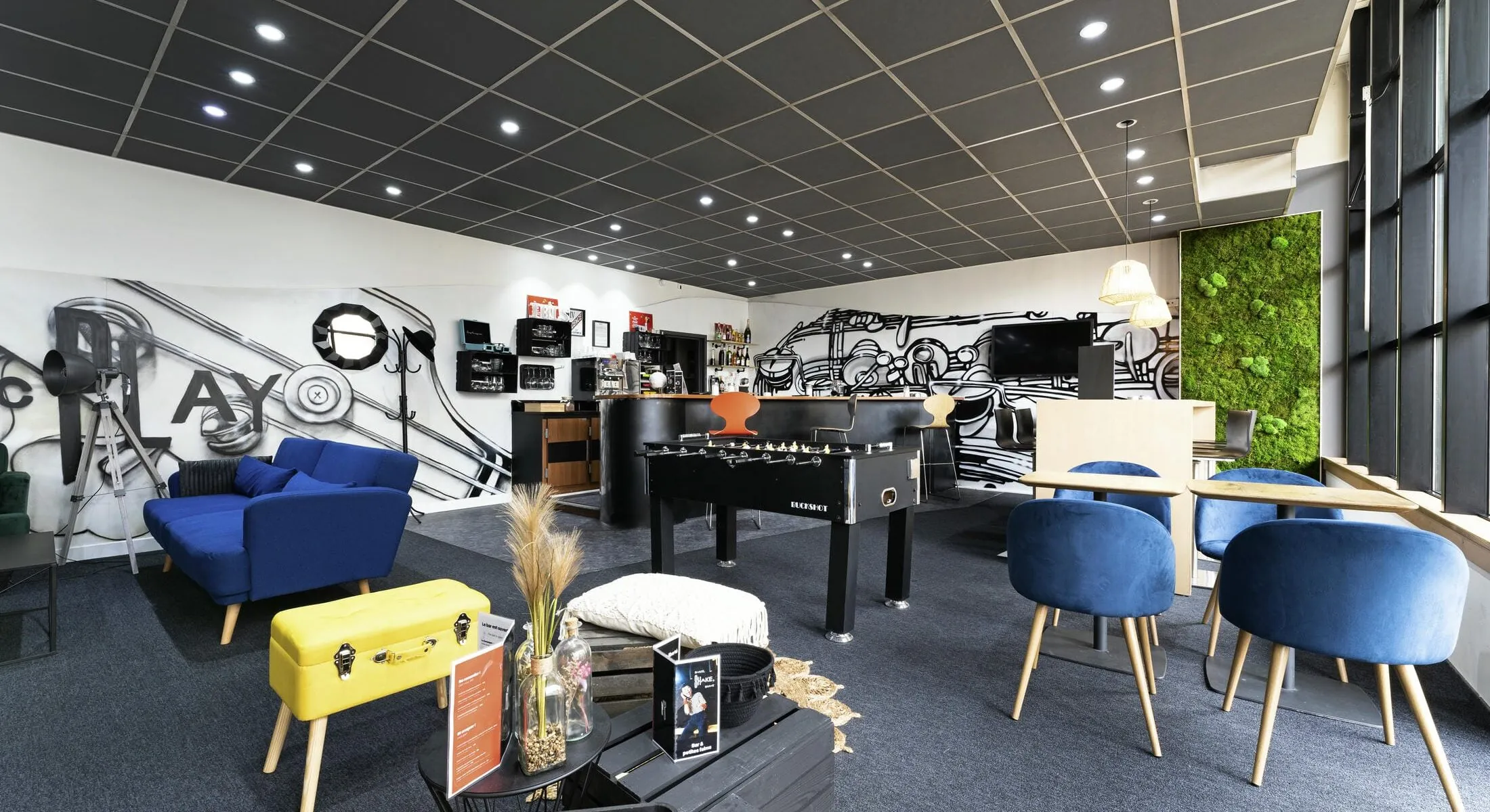 une pièce avec un canapé, des chaises et un baby-foot