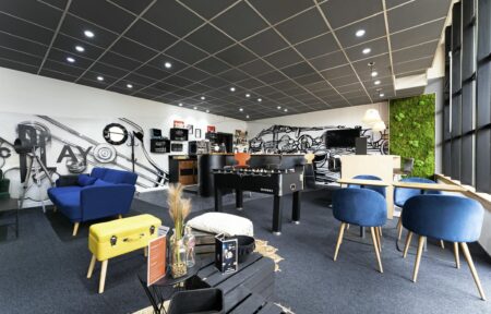 une pièce avec un canapé, des chaises et un baby-foot