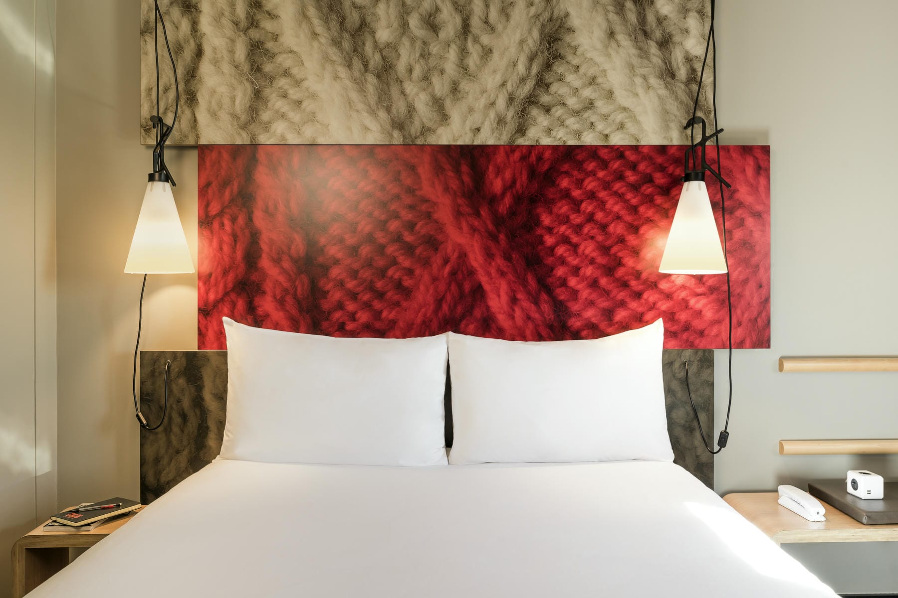 un lit avec une tête de lit en tricot rouge et blanc