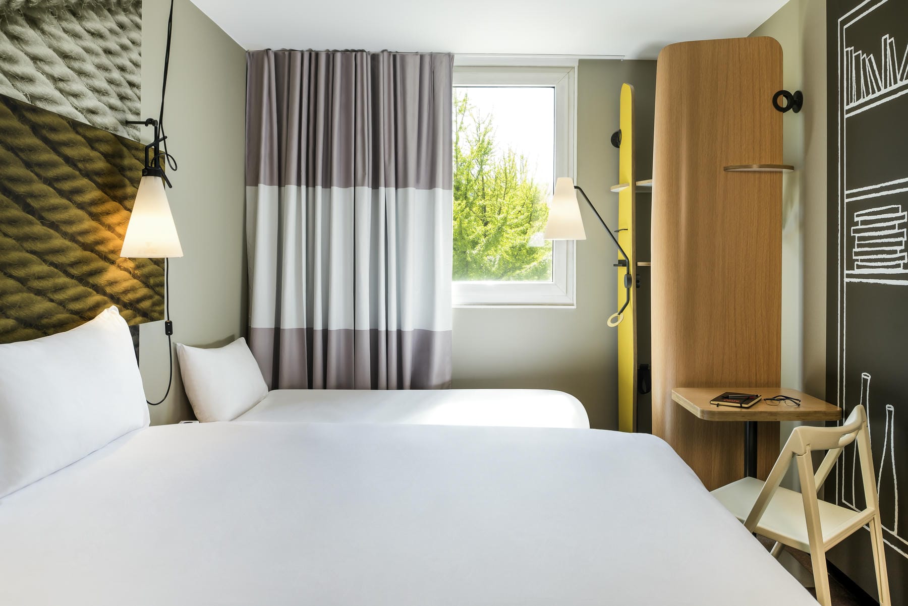 une chambre d'hôtel avec deux lits et un bureau