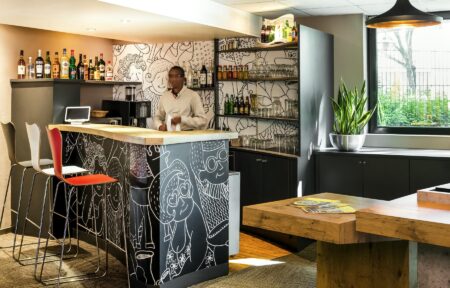 un homme se tient derrière le bar d'un restaurant