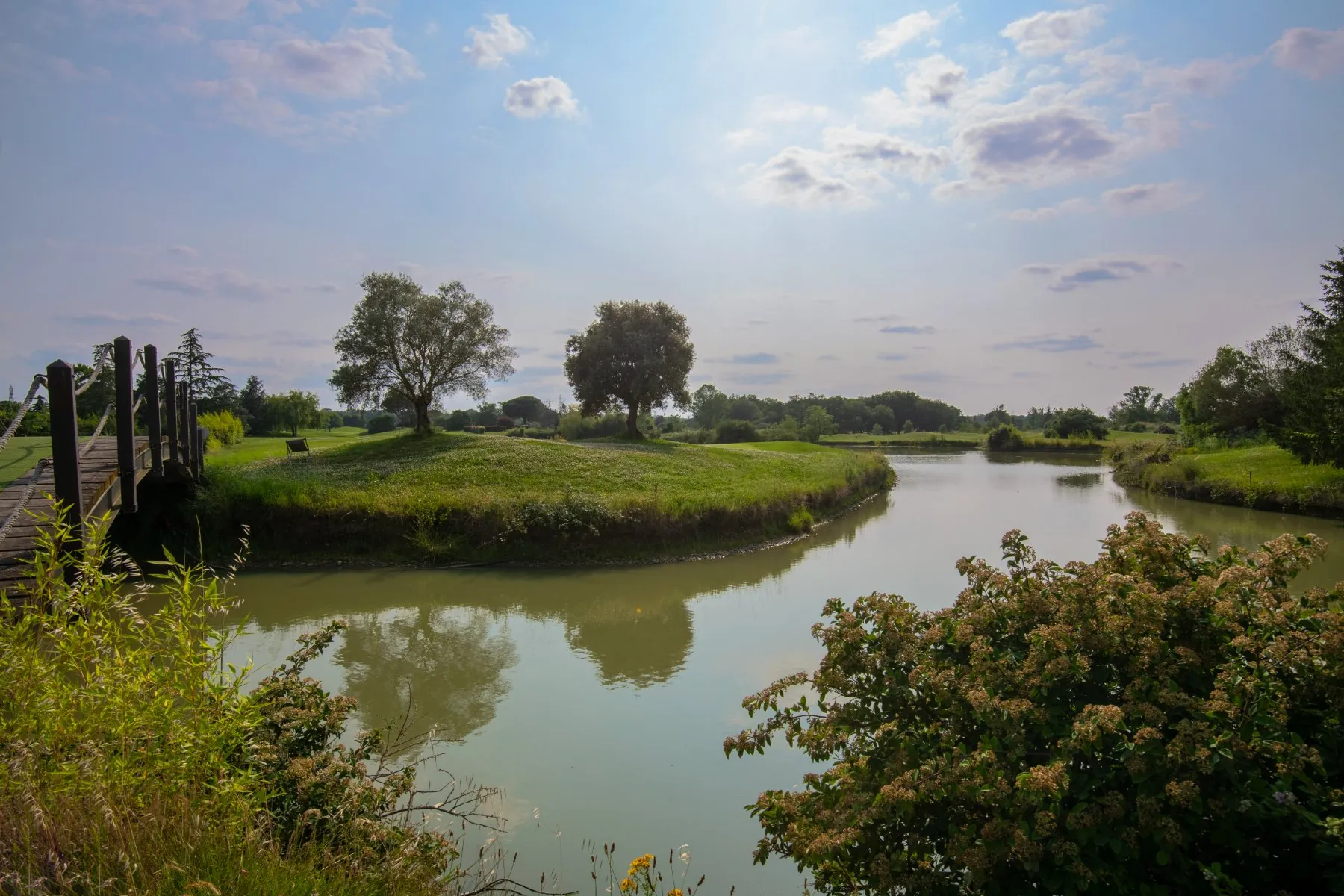 Vue depuis le pont en bois tout en arrondi situé entre l'hôtel et le parcours de golf de Seilh