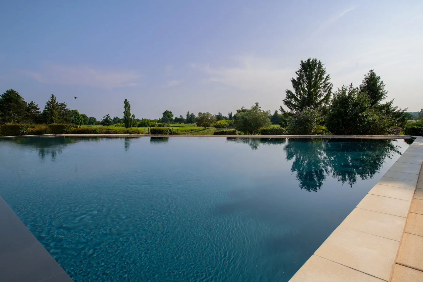 Vue depuis l’espace piscine avec panorama sur le parcours de golf