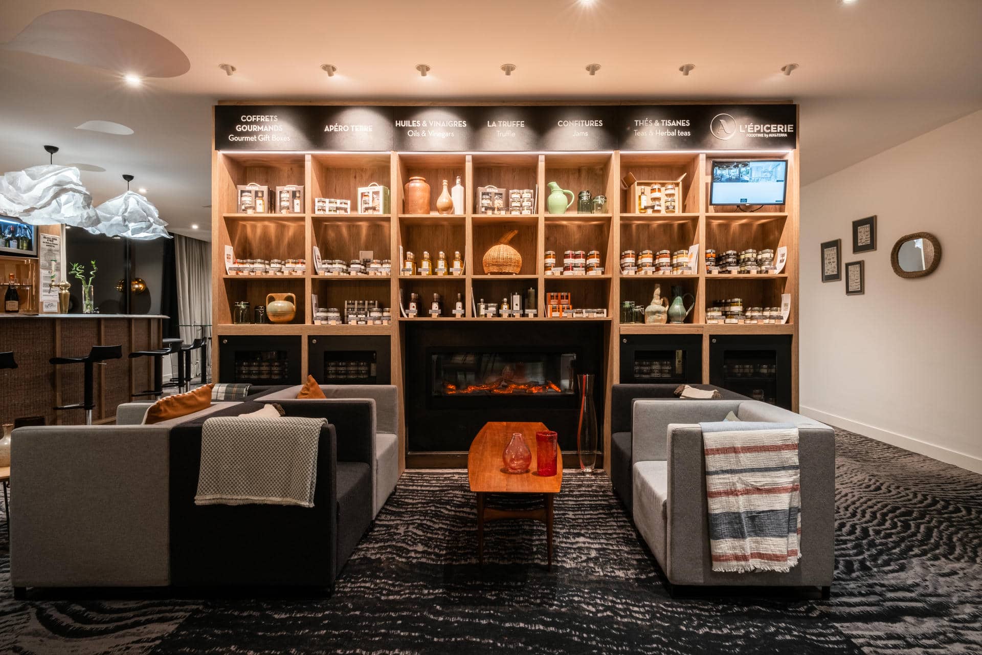 Vue sur un salon qui donne sur une étagère A l'Epicerie