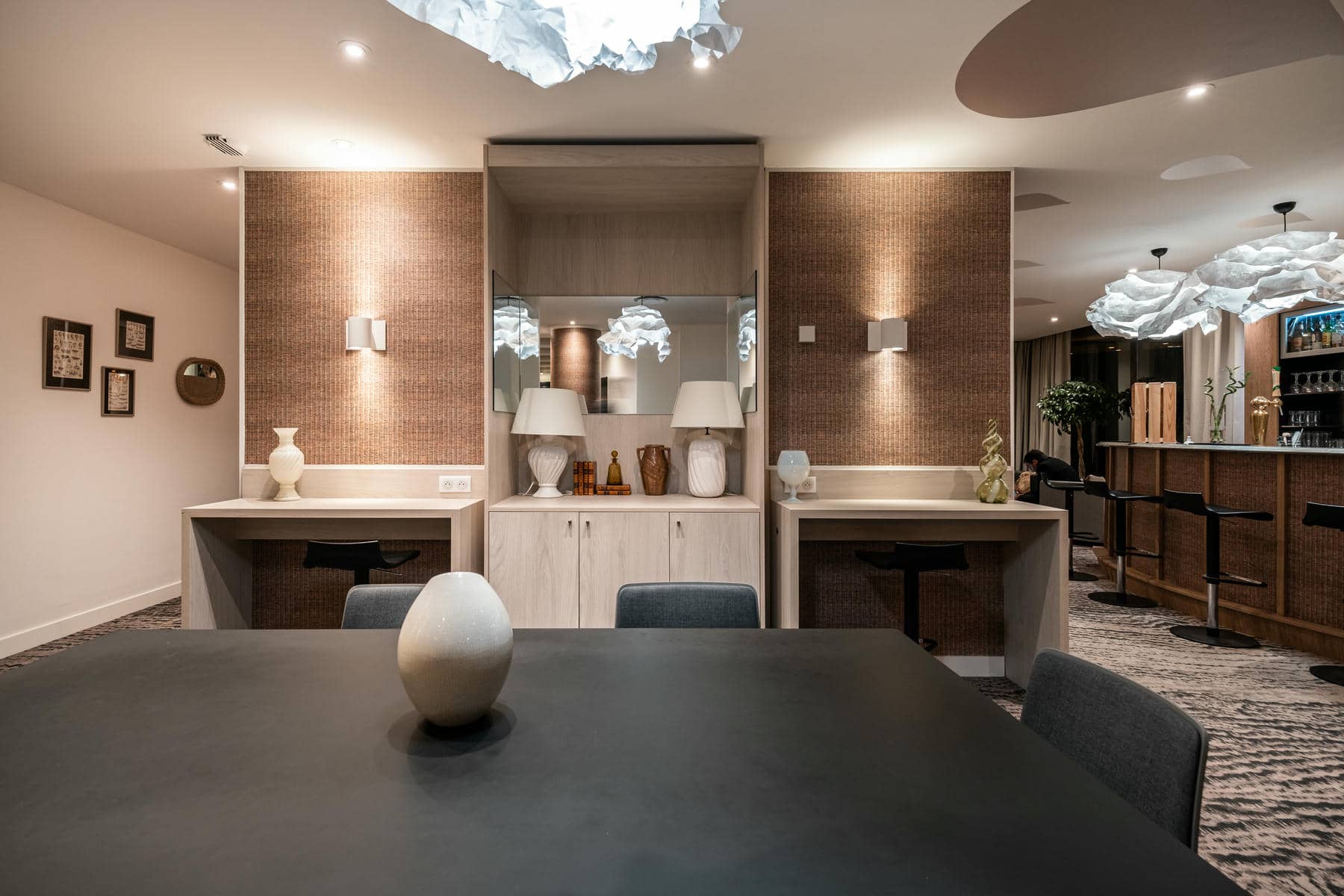 une salle à manger avec table, chaises et lampes