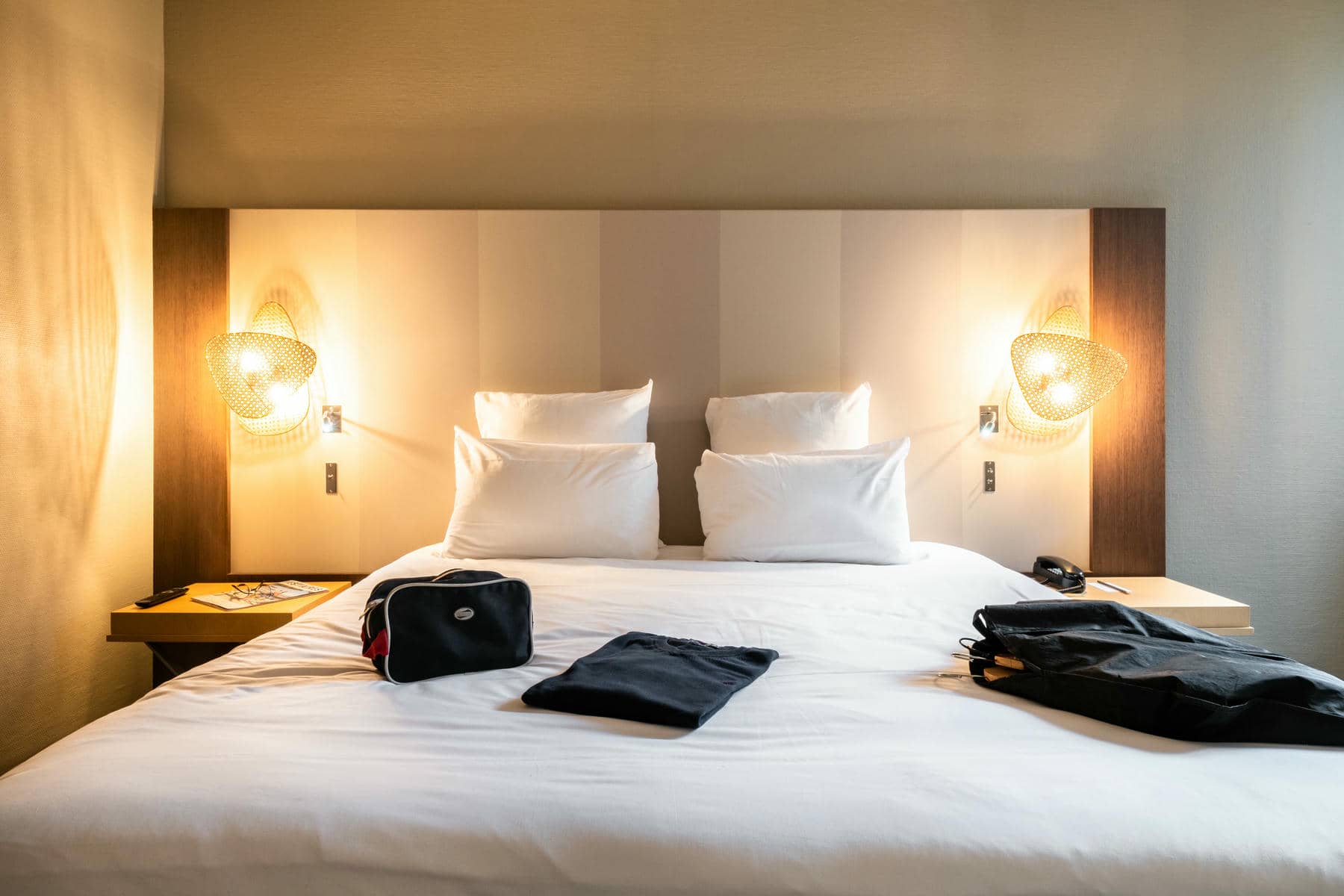 une chambre d'hôtel avec un lit et un sac dessus