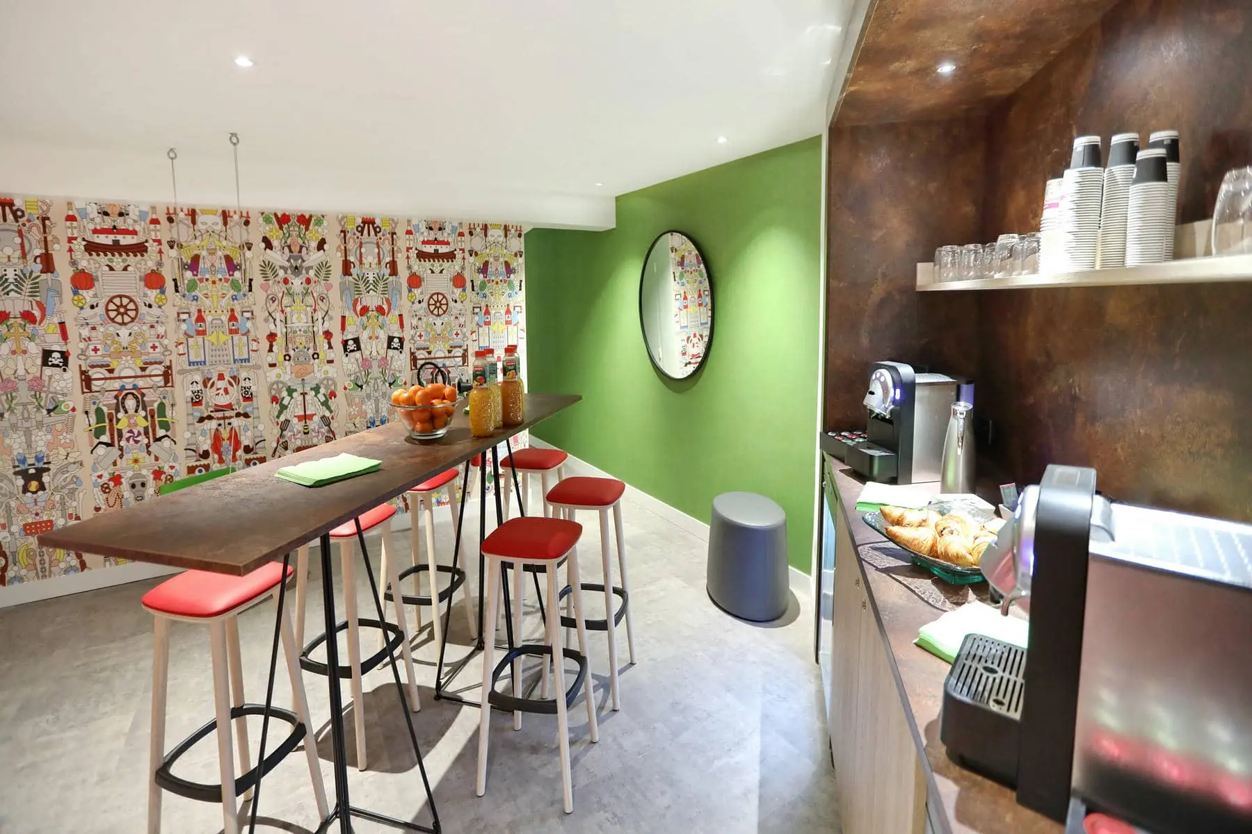 une pièce avec un mur vert et une table avec des tabourets