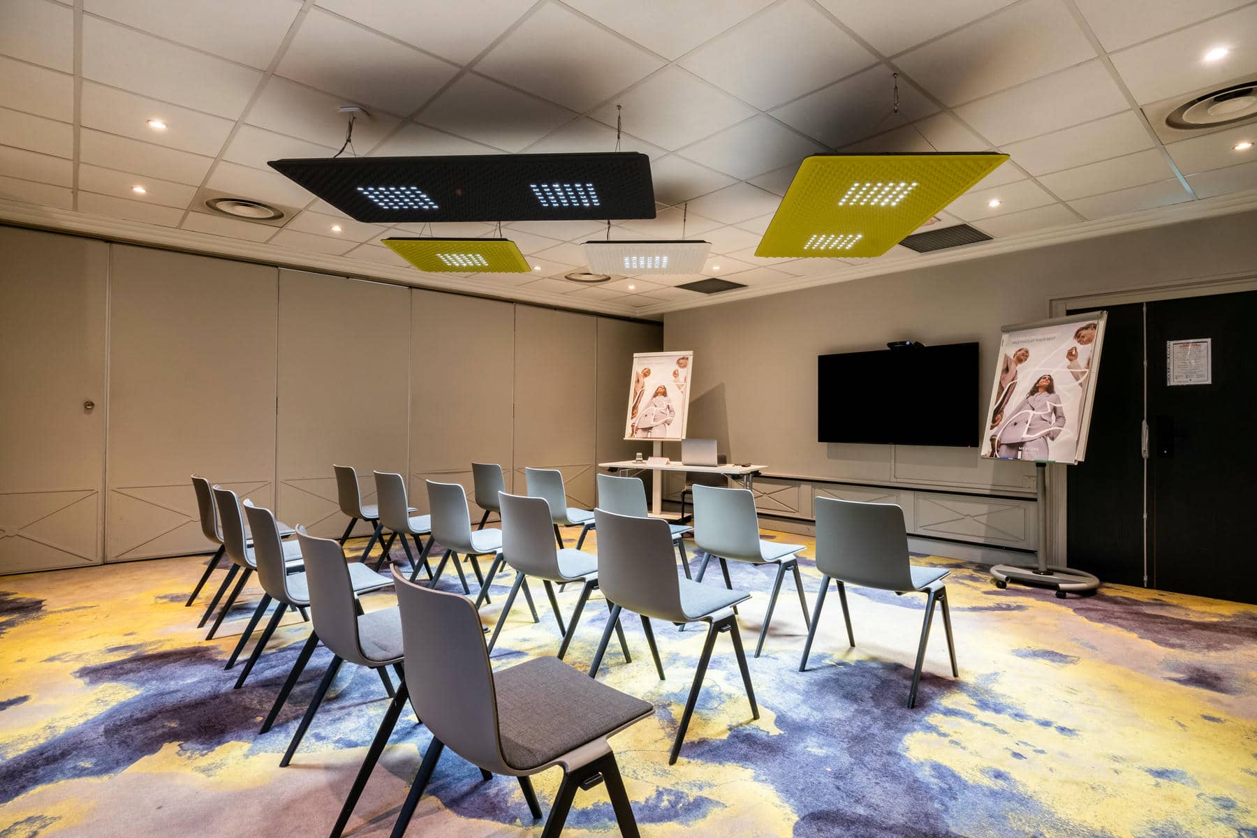 une salle de conférence avec des rangées de chaises et un grand écran