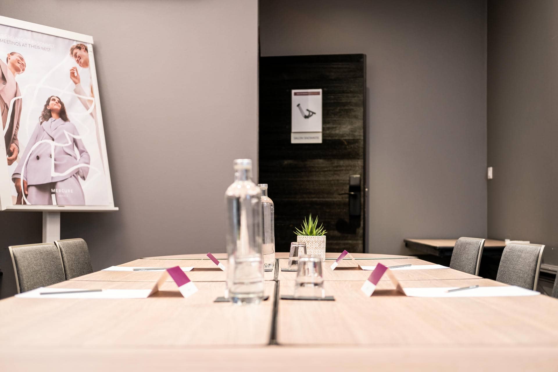 une salle de conférence avec une bouteille d'eau et des verres