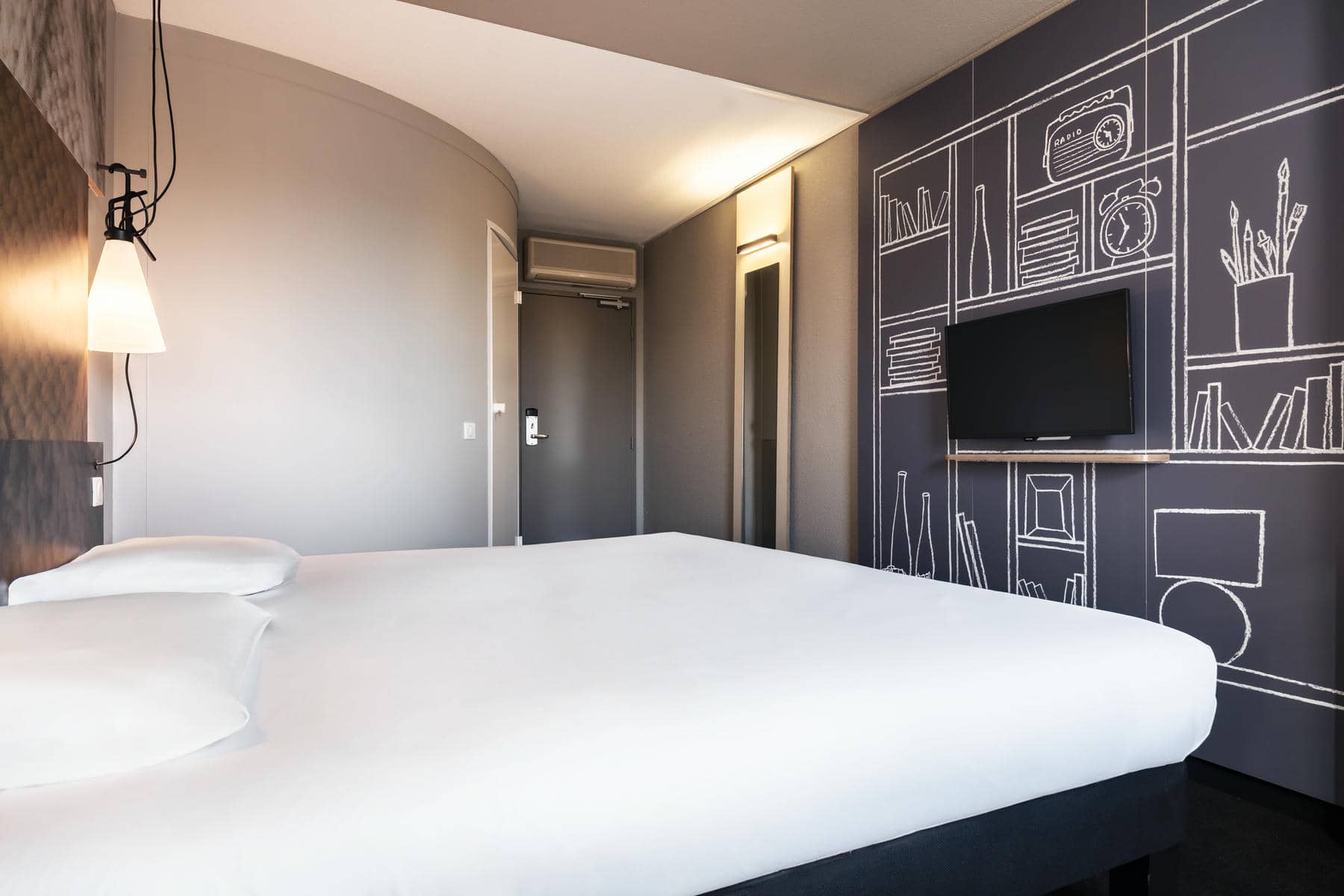 a hotel room with a bed and a television