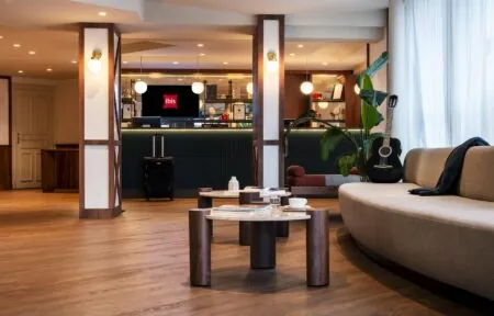 an ibis hotel lobby with a couch and a guitar