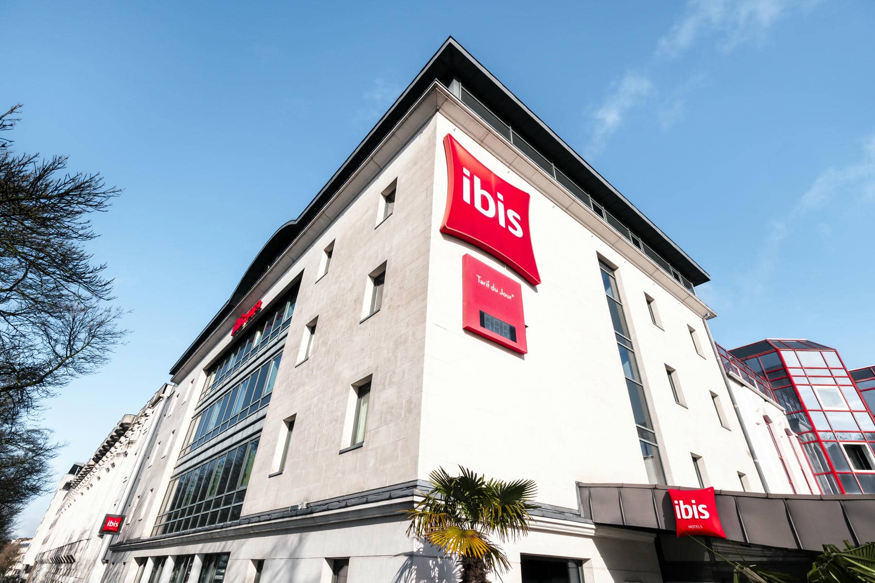 a white building with a red sign that says ibis